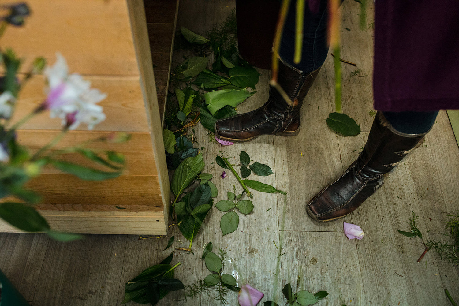 Bouquet making workspace. Elise creating bouquets and cutting flower stems to size.