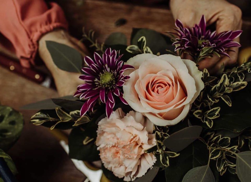 Small bouquet of flowers made with pink, purple, and green florals.